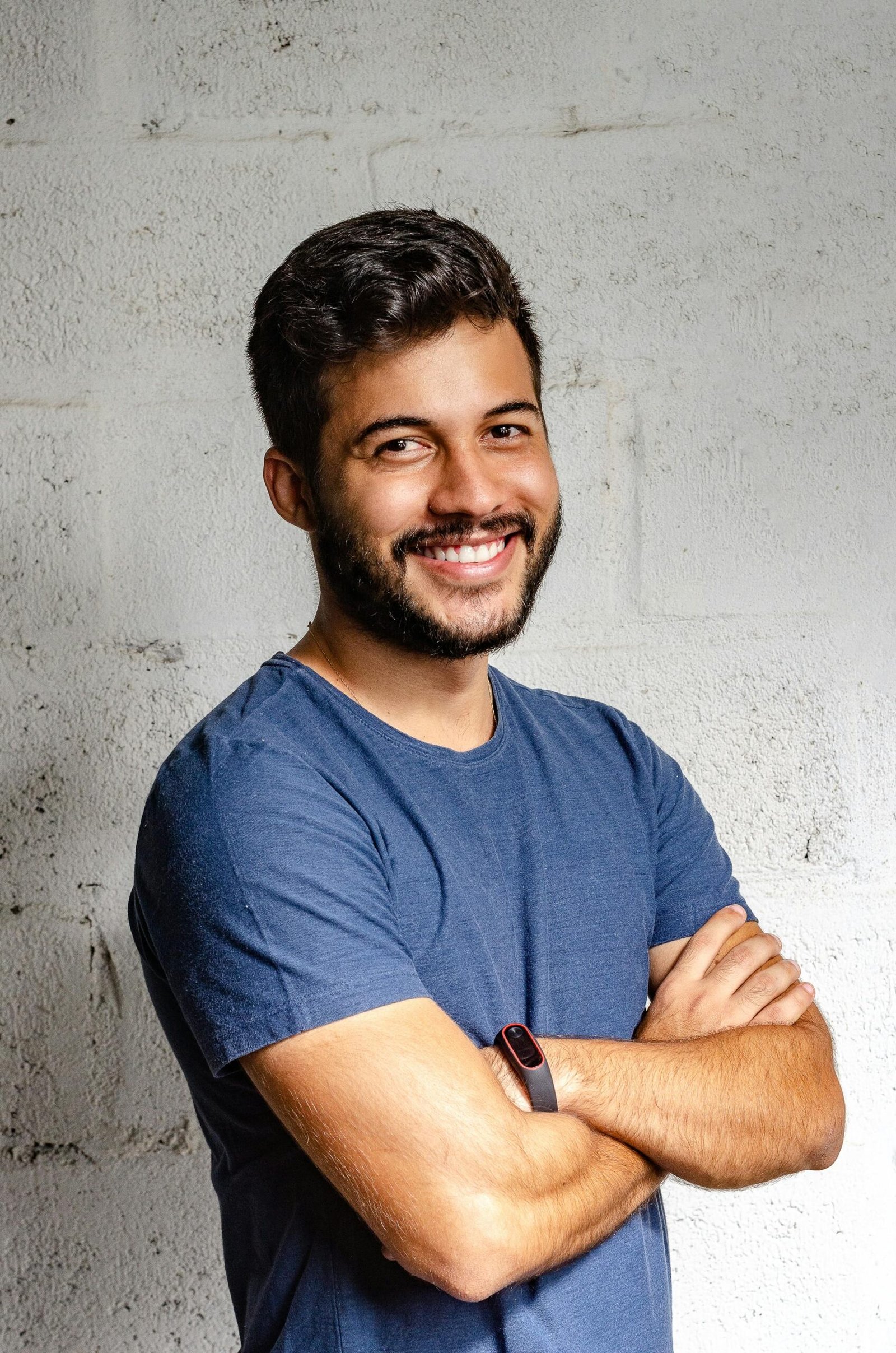 Portrait of a happy man with arms crossed, exuding confidence and friendliness.